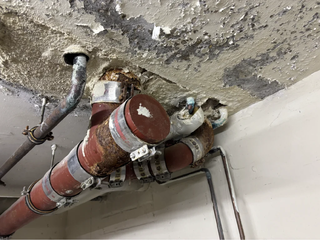 Wasserschaden und Feuchtigkeit an Decke mit korrodierten Rohren – Begutachtung durch Bausachverständiger Fuhrmann