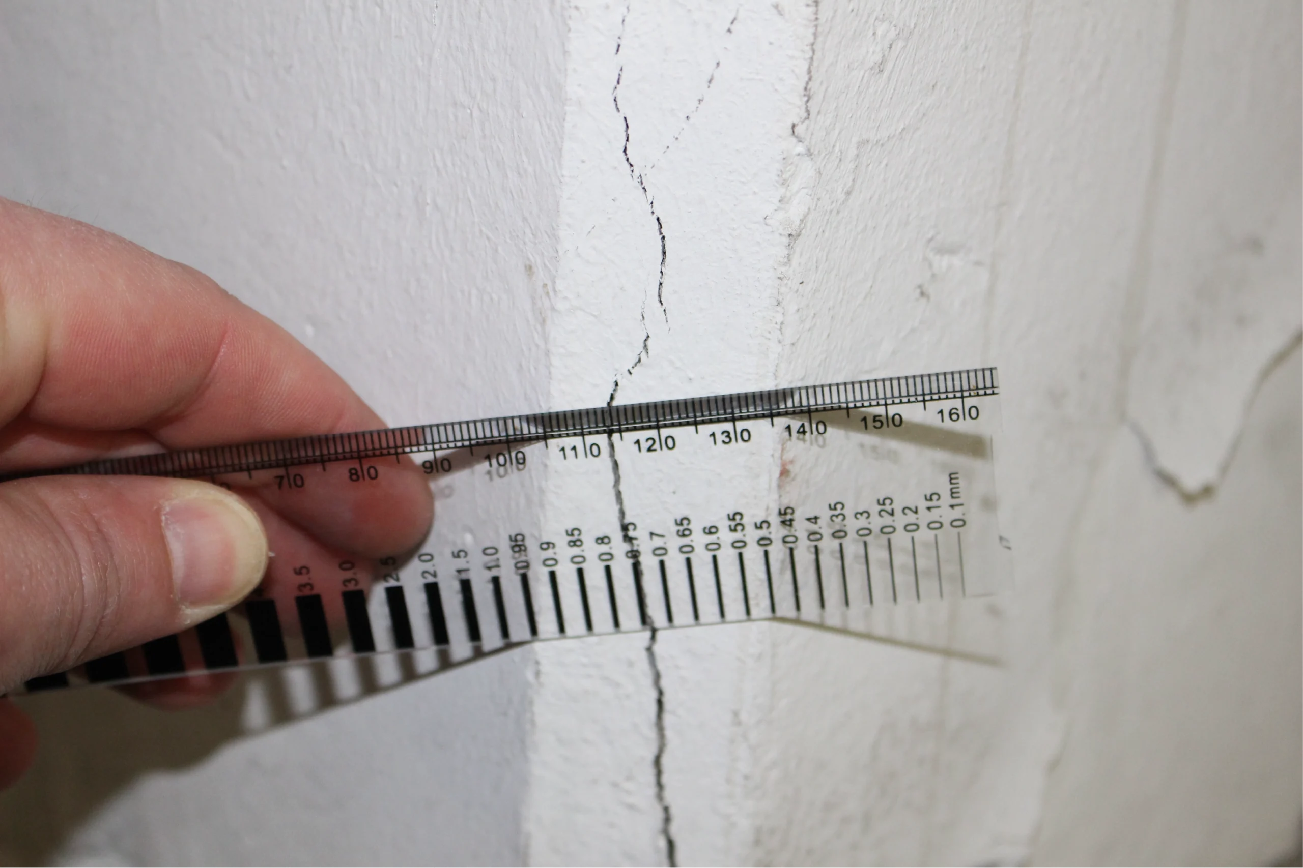Messung eines Wandrisses mit Risslineal zur Schadensanalyse im Bauwesen