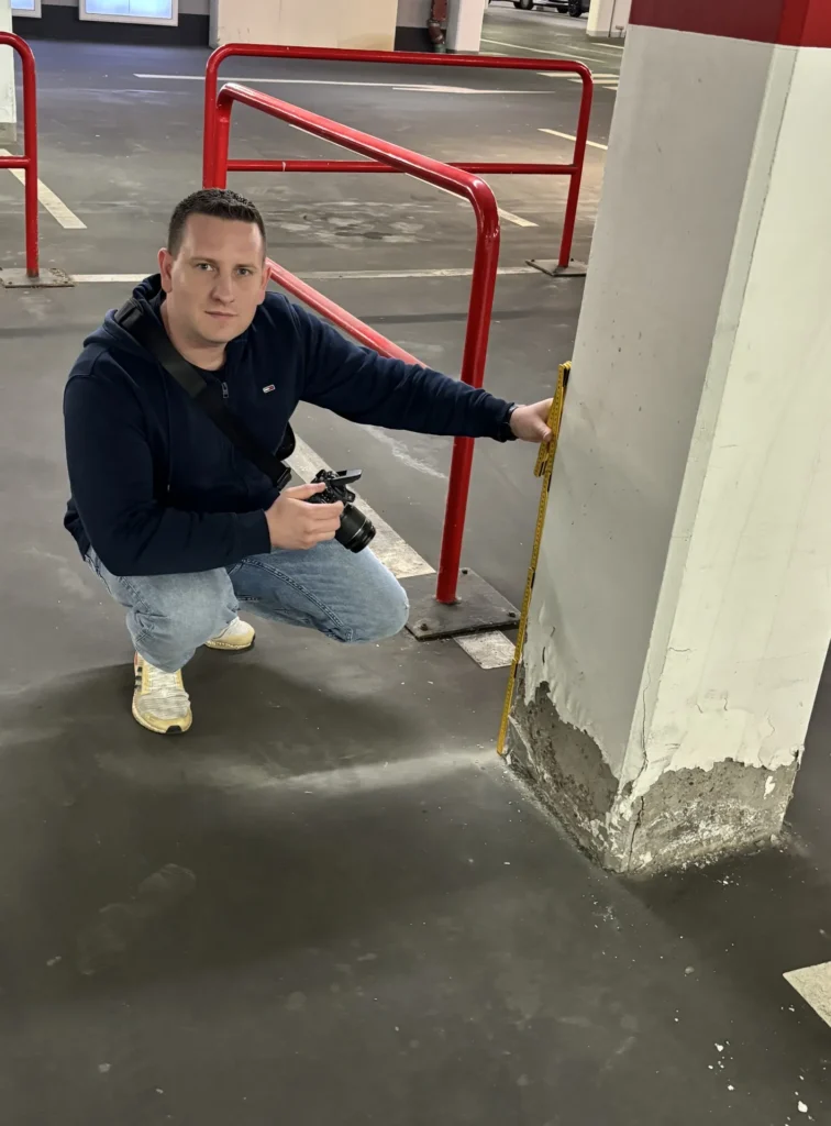 Sachverständiger misst Feuchtigkeitsschaden an Betonsäule in Tiefgarage – Schadensdokumentation vor Ort