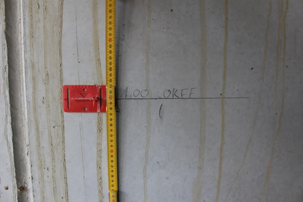Höhenmarkierung und Maßaufnahme an Betonwand – bauliche Kontrolle und Dokumentation durch Sachverständigen