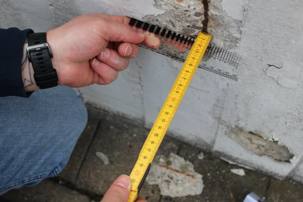 Rissmessung an Betonwand mit Lineal – Schadensanalyse durch Bausachverständigen