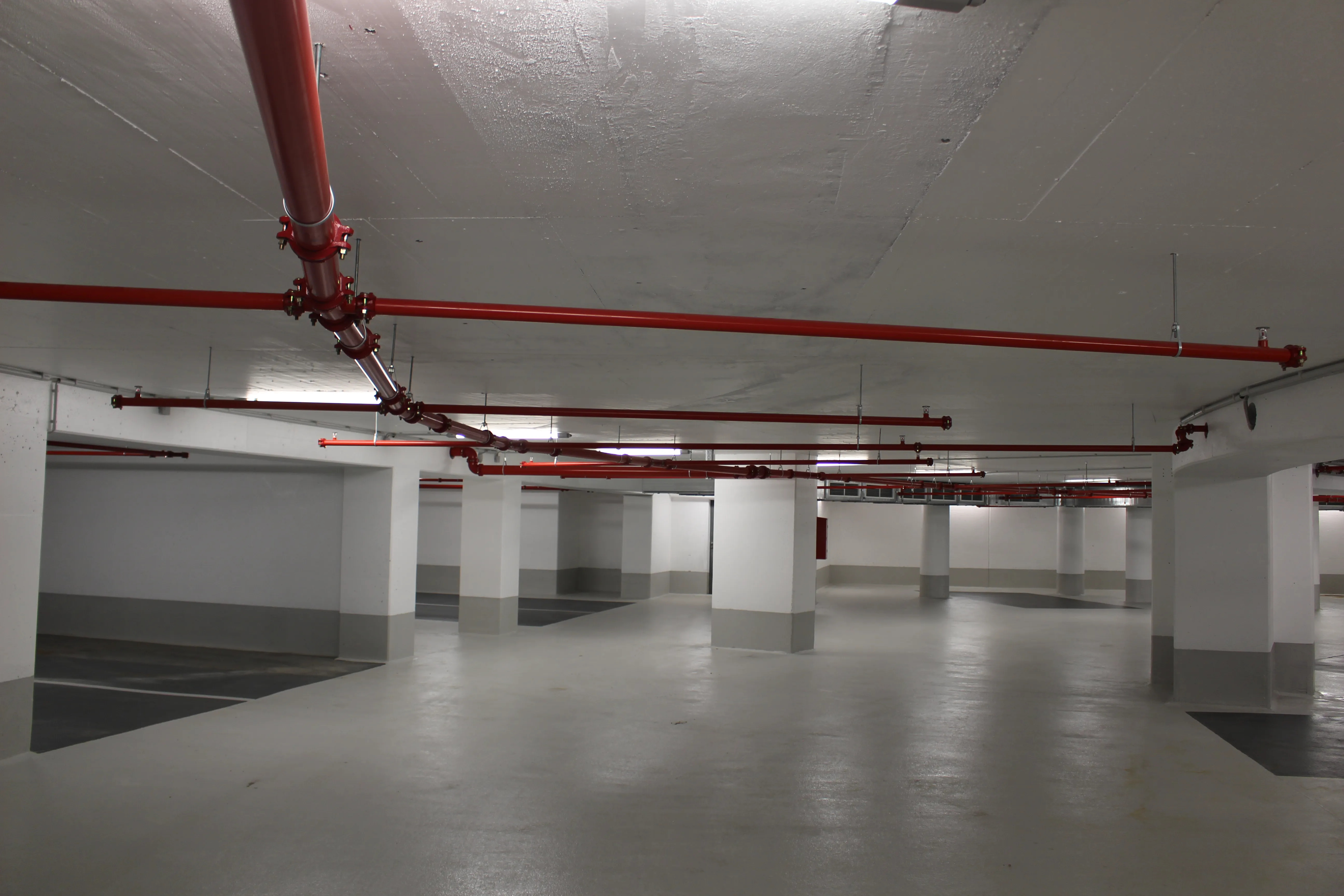 Tiefgarage mit Sprinklerleitungen an der Decke – baulicher Zustand und Nutzung von Stellflächen